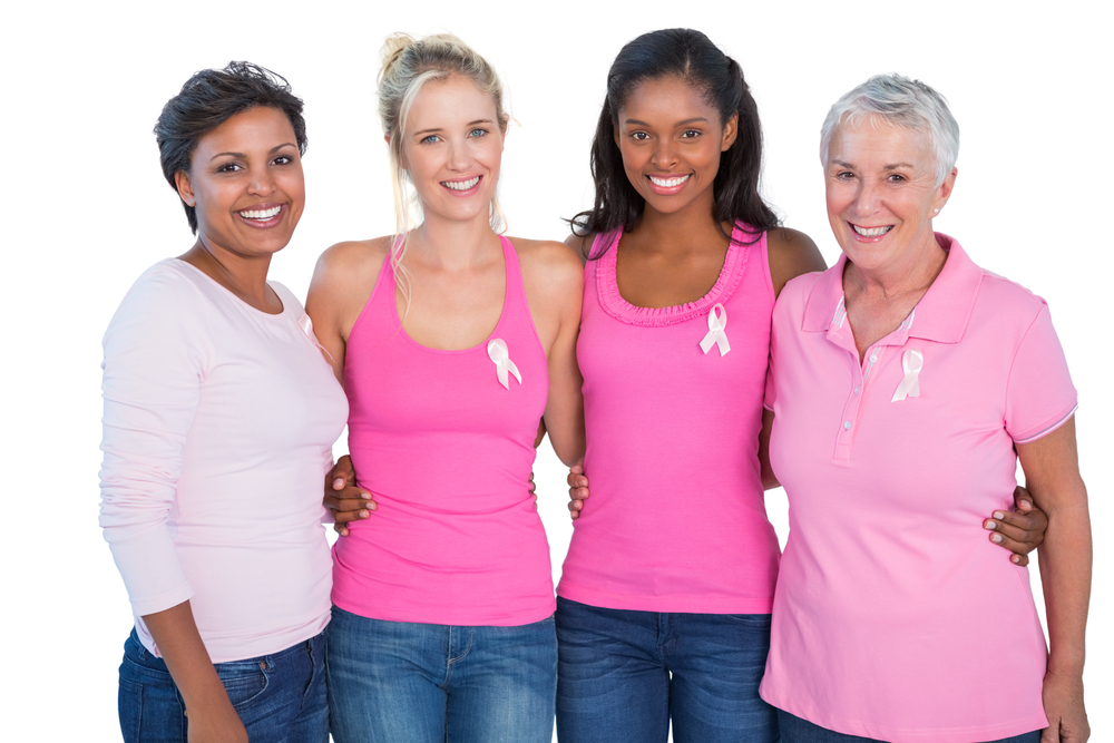 Smiling women wearing pink tops and breast cancer ribbons on white background