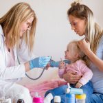 Pediatrician doctor visiting baby at home