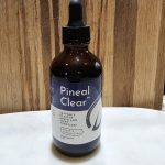 Dropper bottle of Pineal Clear supplement on table.